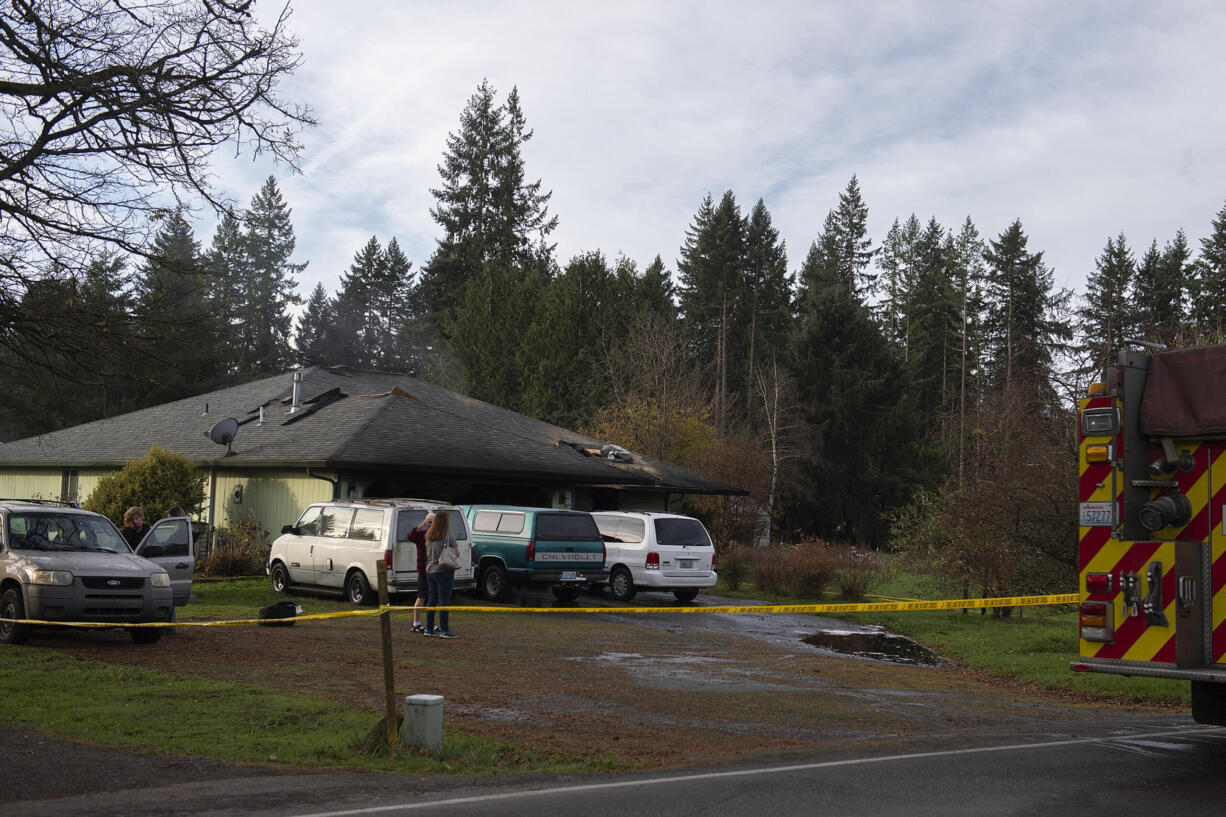 Caution tape surrounds a home along Northeast 99th Street after a fatal fire on Thursday morning, Dec.2, 2021.