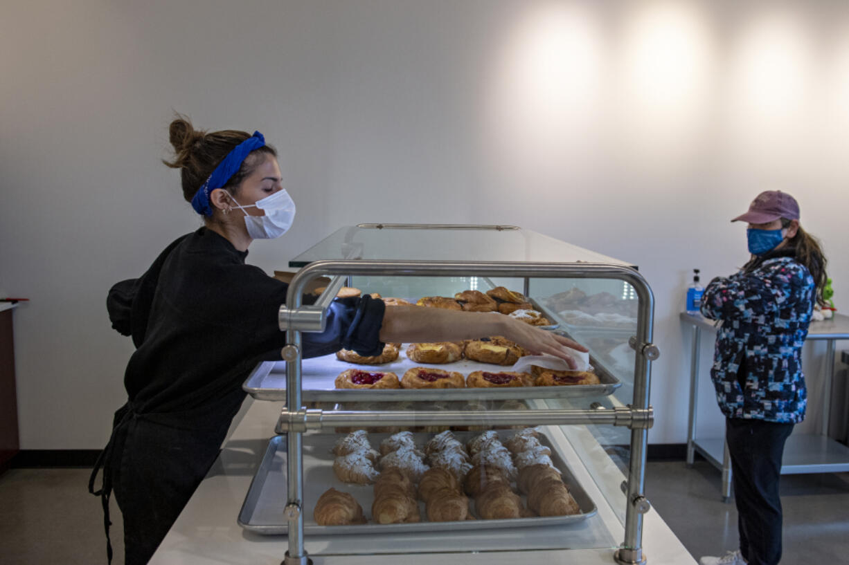 Natalie Rogers of Baron Patisserie, left, helps fill an order for customer Esmeralda Garcia of Camas. The local French bakery has been around for about seven years.