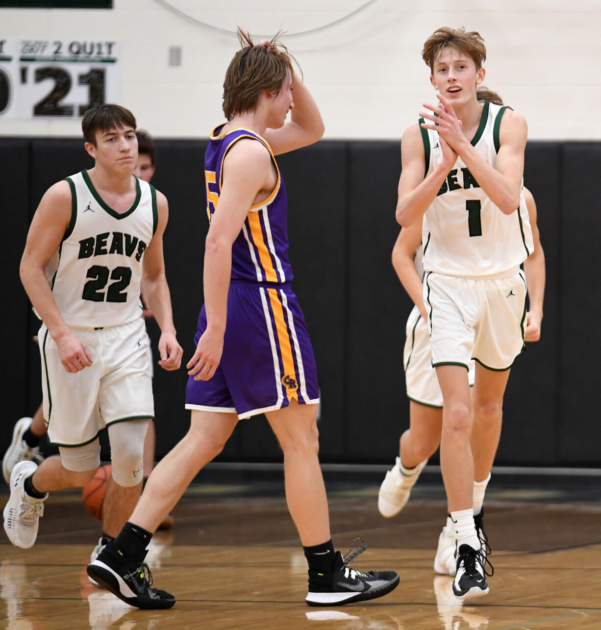 Woodland players clap and walk off the court Tuesday, Dec. 7, 2021, after the Beavers’ 57-41 win against Columbia River at Woodland High School.