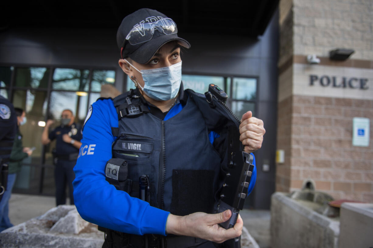 Vancouver bicycle patrol Officer Nicole Vigil displays a hands-free body camera that slips into the front of an officer's vest during a press conference Wednesday afternoon at the Vancouver Police Department's West Precinct. Vancouver police officers are testing out body-worn and dash cameras as a part of the department's 60-day pilot launch of the system.