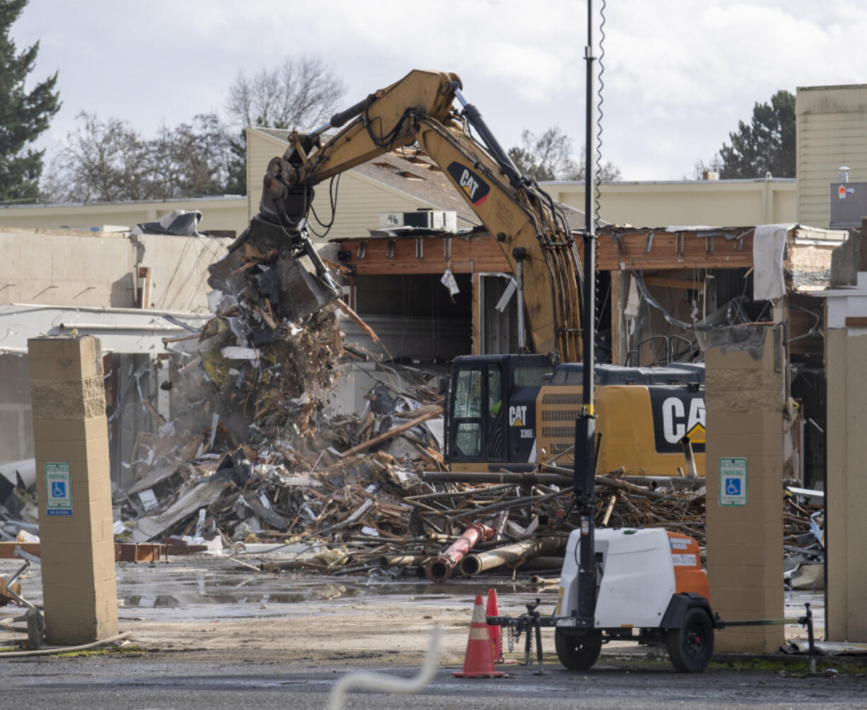 An excavator loads debris into trucks Wednesday at Vancouver's former Tower Mall. The building is being demolished as part of The Heights District Plan, an initiative by the city of Vancouver to transform the site into a mixed commercial and residential space.