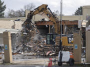 An excavator loads debris into trucks Wednesday at Vancouver's former Tower Mall. The building is being demolished as part of The Heights District Plan, an initiative by the city of Vancouver to transform the site into a mixed commercial and residential space.