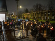 Vigil attendees hold candles and listen to speakers Tuesday at St. Paul Lutheran Church during a candlelight vigil honoring those who died while experiencing homelessness.