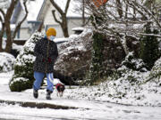 Cindy Steffen of Battle Ground keeps in step with her dog, Hato, 2, as they enjoy a brisk but scenic walk around their neighborhood Monday morning, Dec. 27, 2021. Forecasters predict the cold temperatures and chance of snow will stick around for most of the week.