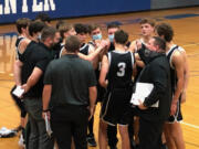 The Woodland boys basketball team gathers for a cheer after beating La Center 55-49 on Wednesday at La Center High School.