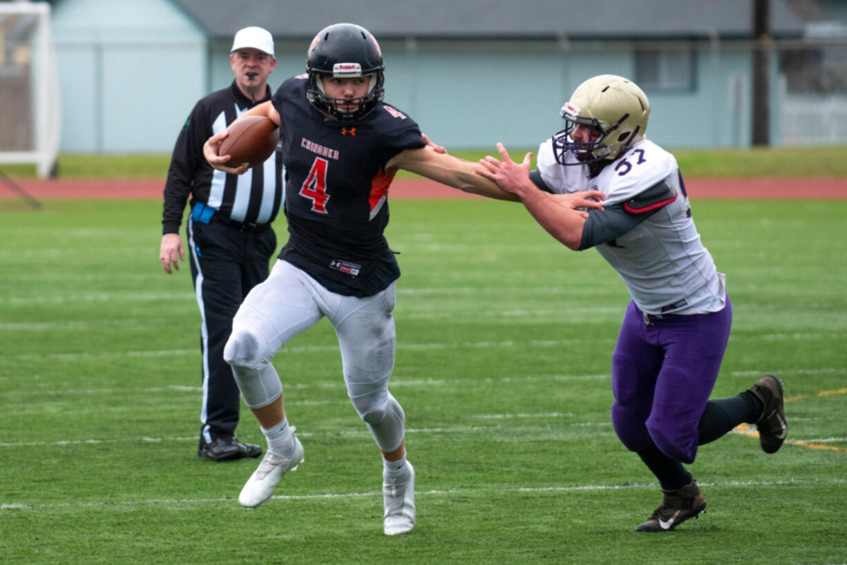 Kalama quarterback Jackson Esary (4) tries to elude Onalaska's Daniel Malott (57) in the 2B state semifinal on Nov. 27.