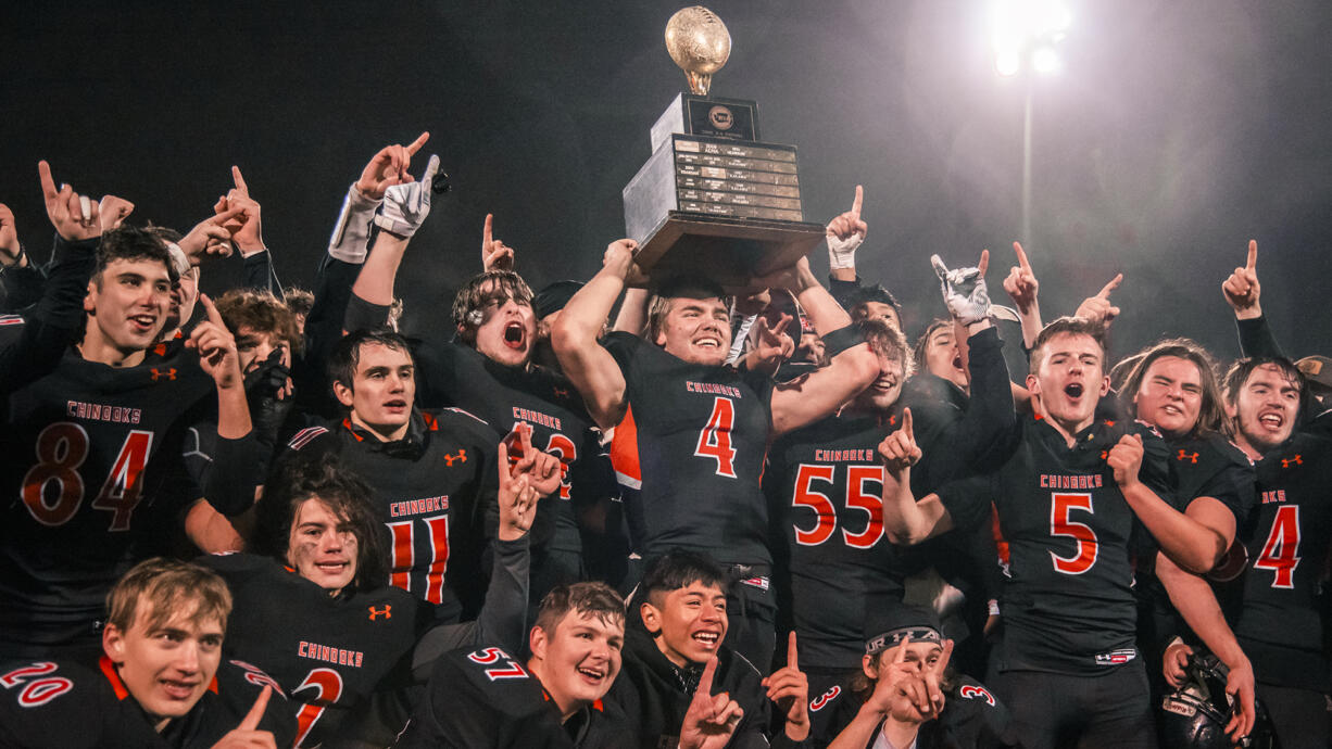 Kalama’s Jackson Esary (4) holds up the WIAA Class 2B state football trophy while surrounded by teammates after beating Napavine 16-14 on Saturday, Dec. 4, 2021, at Harry E. Lang Stadium in Lakewood.