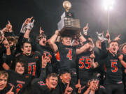 Kalama’s Jackson Esary (4) holds up the WIAA Class 2B state football trophy while surrounded by teammates after beating Napavine 16-14 on Saturday, Dec. 4, 2021, at Harry E. Lang Stadium in Lakewood.