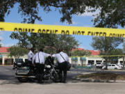 Palm Beach County Sheriff???s officers stand outside of a Publix supermarket where a woman,  child and a man were found shot to death on June 10, 2021, in Royal Palm Beach, Florida.