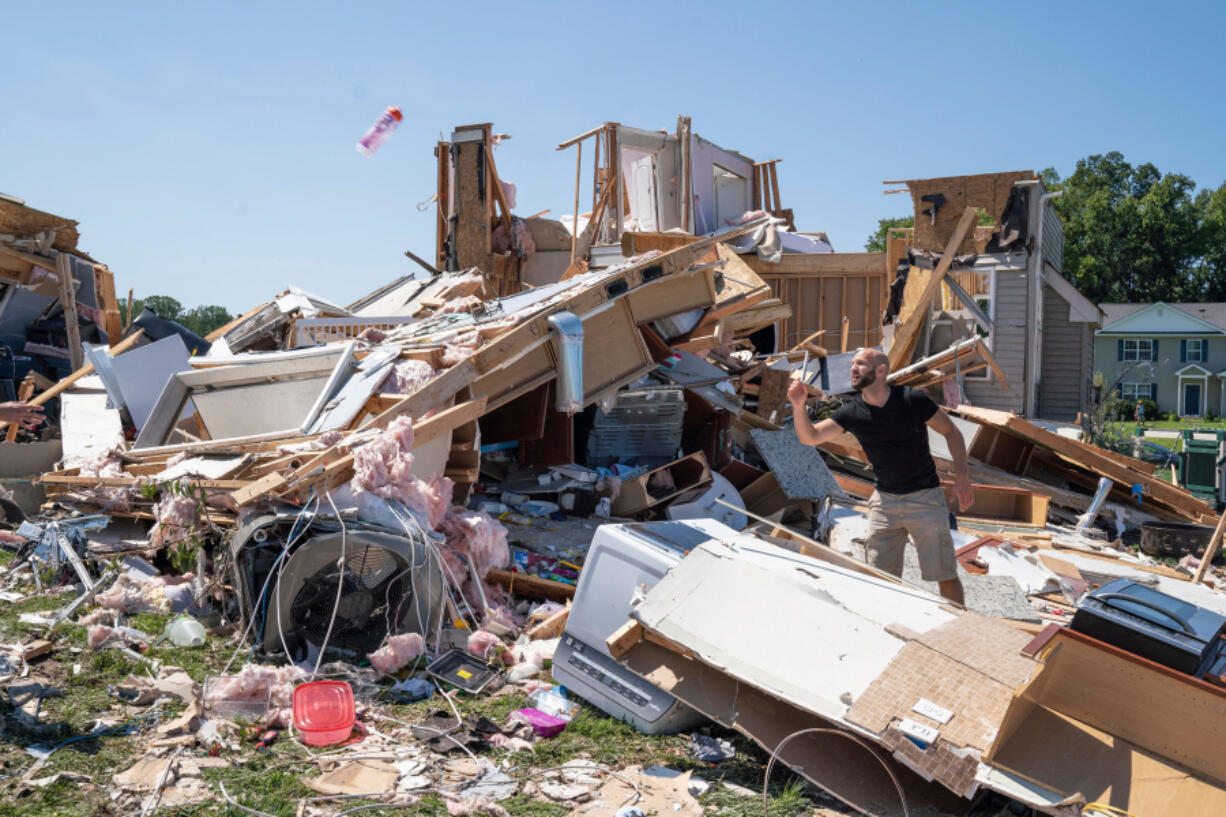 Sam Catrambone clears debris away from a friend's home, damaged by a tornado in Mullica Hill, New Jersey on Sept. 2, 2021 after record-breaking rainfall brought by the remnants of Hurricane Ida swept through the area.