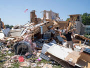 Sam Catrambone clears debris away from a friend's home, damaged by a tornado in Mullica Hill, New Jersey on Sept. 2, 2021 after record-breaking rainfall brought by the remnants of Hurricane Ida swept through the area.