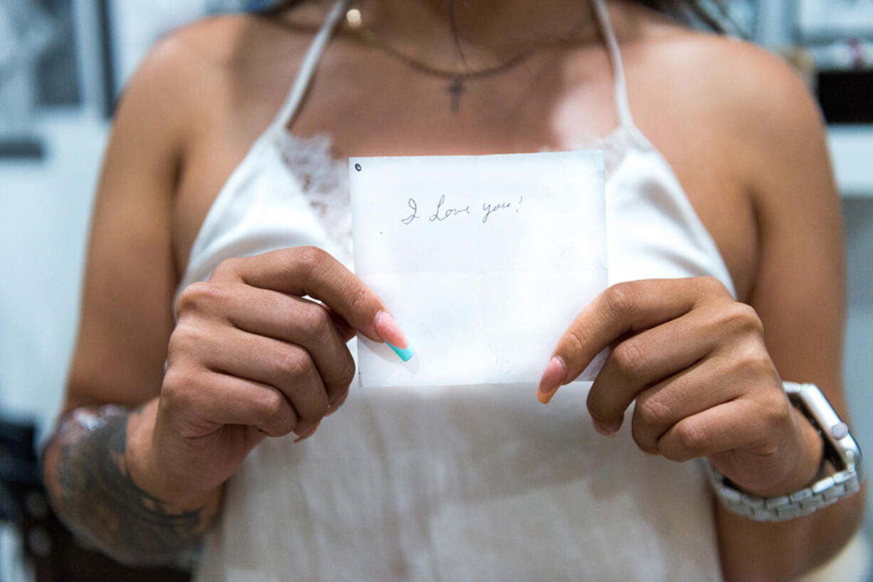 Sazalea Martinez, a kinesiology student at Antelope Valley College in Palmdale, California, holds a handwritten note from her grandmother with the phrase "I love you." (Heidi de Marco/Kaiser Health News/TNS)