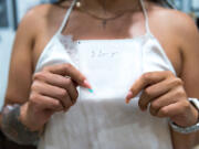 Sazalea Martinez, a kinesiology student at Antelope Valley College in Palmdale, California, holds a handwritten note from her grandmother with the phrase "I love you." (Heidi de Marco/Kaiser Health News/TNS)