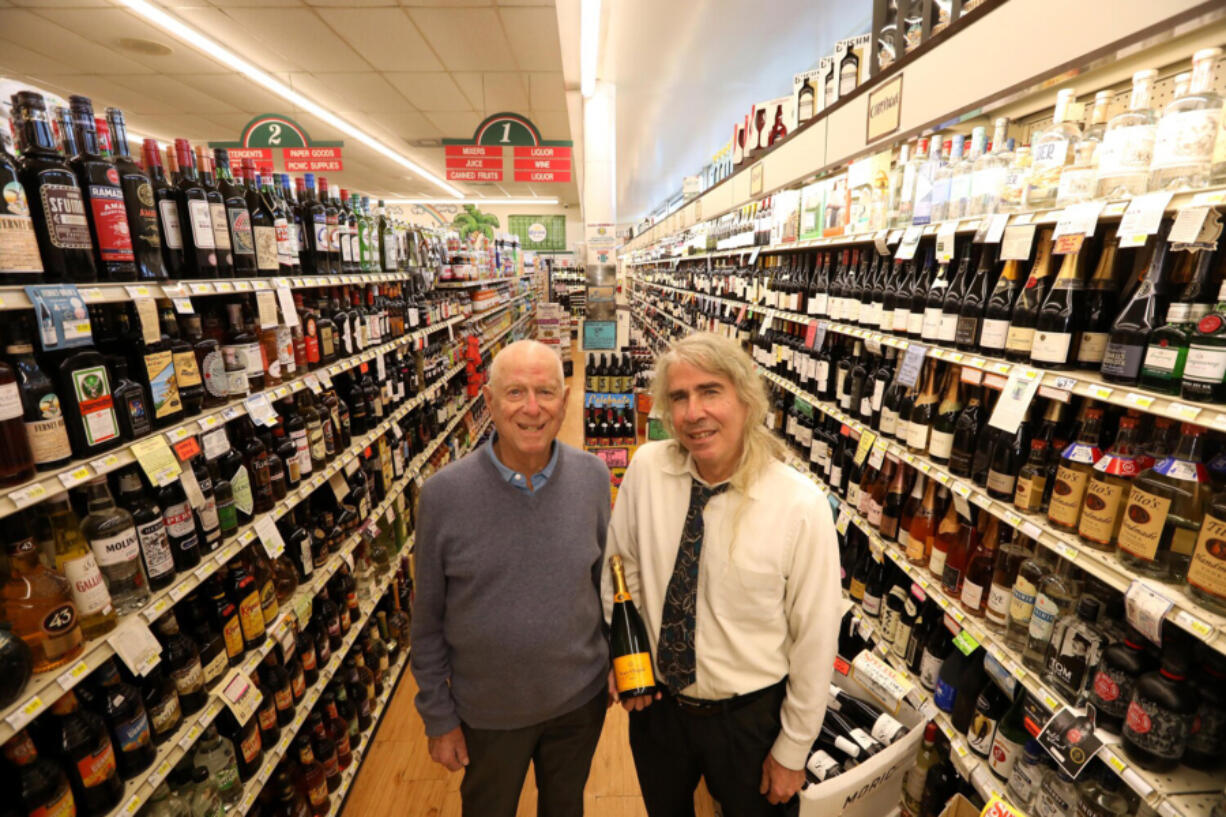 Bob Rosenbloom, 89, left, owner of Bob's Market, and his son Rick, 66 -- holding a $69.99 bottle of Veuve Cliquot champagne that sold for $52 a month ago -- stand in an aisle of the Santa Monica, Calif., store.