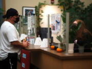 Peer specialist John Amato, left, chats with a receptionist at Columbia River Mental Health Services' NorthStar Clinic in central Vancouver on Dec. 14. Amato has lived experience with addiction. He helps patients navigate through recovery and connects them with resources.