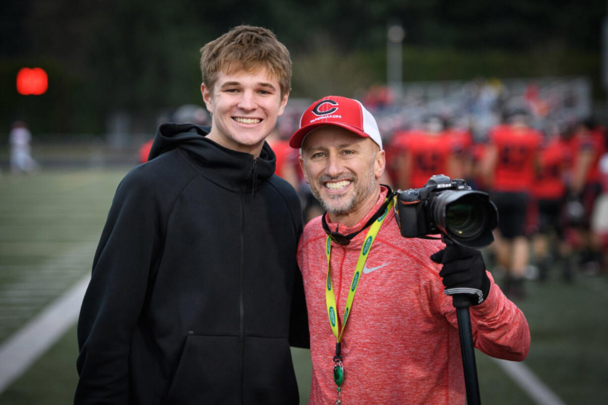 Kris Cavin (right) poses with Camas player Jake Blair on the sidelines at a Camas football game in 2019 (Ken Nowaczyk/For The Columbian)