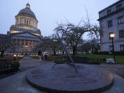 People walk past the sundial near the Legislative Building in Olympia just before dusk on Tuesday, the shortest day of the year. (ted s.