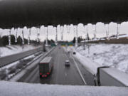 Top: Icicles hang from the railing of a bridge as sporadic traffic flows smoothly in the northbound lane of Interstate 205 following an ice storm Feb.