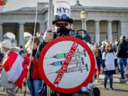 FILE - A man takes part in a demonstration against the country's coronavirus restrictions in Vienna, Austria, Saturday, Nov. 20, 2021. The coronavirus's omicron variant kept a jittery world off-kilter Wednesday Dec.