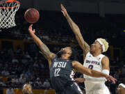 Washington State guard Michael Flowers (12) drives past Arizona State forward Jalen Graham during the first half of an NCAA college basketball game Wednesday, Dec. 1, 2021, in Tempe, Ariz.