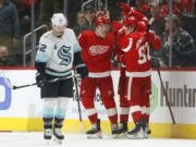 Detroit Red Wings center Vladislav Namestnikov (92) celebrates his goal with defenseman Moritz Seider (53) and left wing Adam Erne, second from left, as Seattle Kraken center Mason Appleton (22) skates away during the second period of an NHL hockey game Wednesday, Dec. 1, 2021, in Detroit.