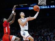 Gonzaga guard Andrew Nembhard, right, goes up for a shot against Texas Tech guard Davion Warren, left, during the first half of an NCAA college basketball game at the Jerry Colangelo Classic Saturday, Dec. 18, 2021, in Phoenix. (AP Photo/Ross D.