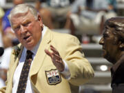 FILE - Former Oakland Raiders coach John Madden gestures toward a bust of himself during his enshrinement into the Pro Football Hall of Fame in Canton, Ohio, Aug. 5, 2006. John Madden, the Hall of Fame coach turned broadcaster whose exuberant calls combined with simple explanations provided a weekly soundtrack to NFL games for three decades, died Tuesday, Dec. 28, 2021, the NFL said. He was 85.