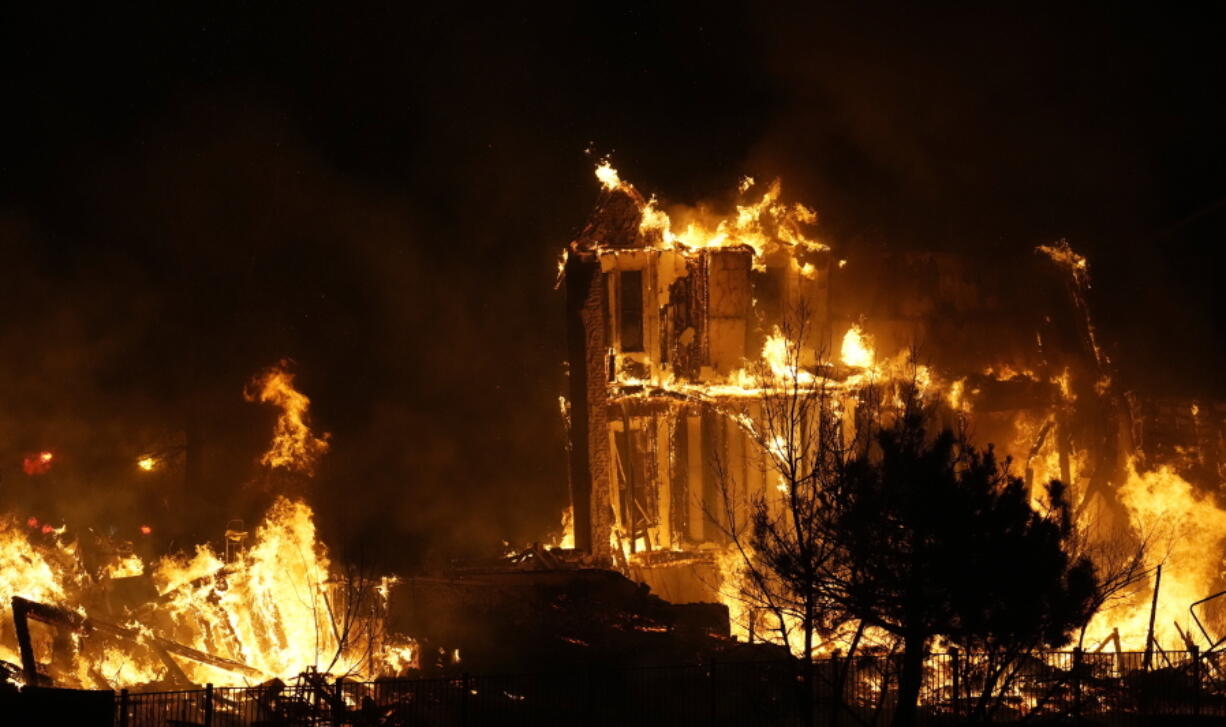 Homes burn as a wildfire rips through a development near Rock Creek Village, Thursday, Dec. 30, 2021, near Broomfield, Colo. An estimated 580 homes, a hotel and a shopping center have burned and tens of thousands of people were evacuated in wind-fueled wildfires outside Denver, officials said Thursday evening.