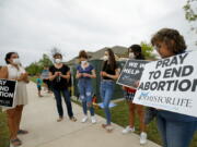 FILE - Anti-abortion demonstrators pray and protest outside of a Whole Women's Health of North Texas, Friday, Oct. 1, 2021, in McKinney, Texas. A federal judge did not say when he would rule following a nearly three-hour hearing in Austin during which abortion providers sought to block the nation's most restrictive abortion law, which has banned most abortions in Texas since early September.