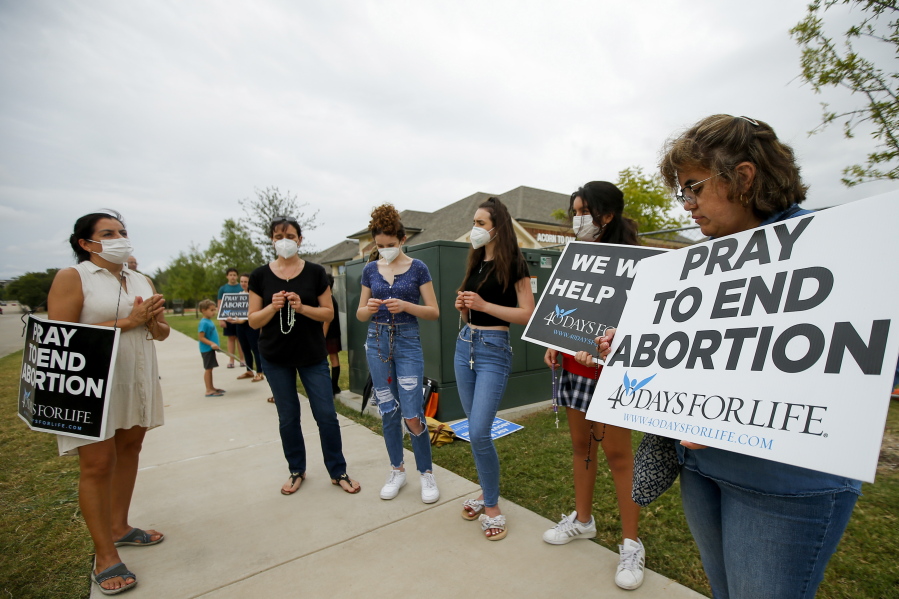 FILE - Anti-abortion demonstrators pray and protest outside of a Whole Women's Health of North Texas, Friday, Oct. 1, 2021, in McKinney, Texas. A federal judge did not say when he would rule following a nearly three-hour hearing in Austin during which abortion providers sought to block the nation's most restrictive abortion law, which has banned most abortions in Texas since early September.