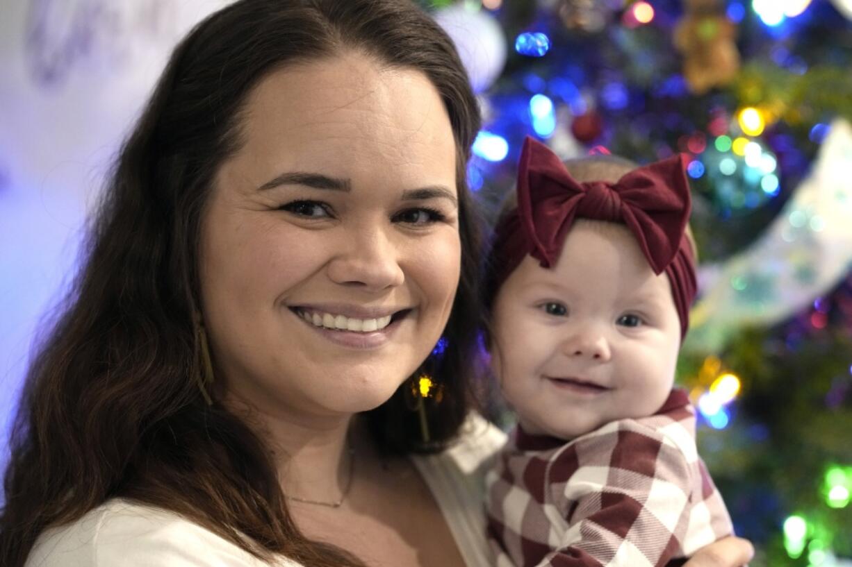 Kelsey Wright holds her 4-month-old daughter, Berklee, on Saturday, Dec. 18, 2021, in Montgomery, Texas. Year after year, several thousand women in the U.S. choose to carry an unintended pregnancy to term and then place the baby for adoption, relinquishing their parental rights. Wright chose adoption -- twice -- before having Berklee. (AP Photo/David J. Phillip) (David J.