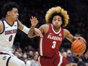 Alabama's JD Davison (3) tries to drive past Gonzaga's Julian Strawther (0) during the first half of an NCAA college basketball game Saturday, Dec. 4, 2021, in Seattle.