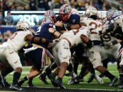 Navy quarterback Tai Lavatai, top center, runs the ball in for a touchdown during the first half of an NCAA college football game against Army, Saturday, Dec. 11, 2021, in East Rutherford, N.J.