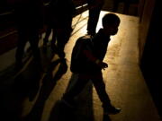 FILE - A student arrives as the sun rises during the first day of school on Wednesday, Aug. 4, 2021 at Freeman Elementary School in Flint, Mich. New autism numbers released Thursday, Dec. 2 suggest more U.S. children are being diagnosed with the developmental condition and at younger ages.