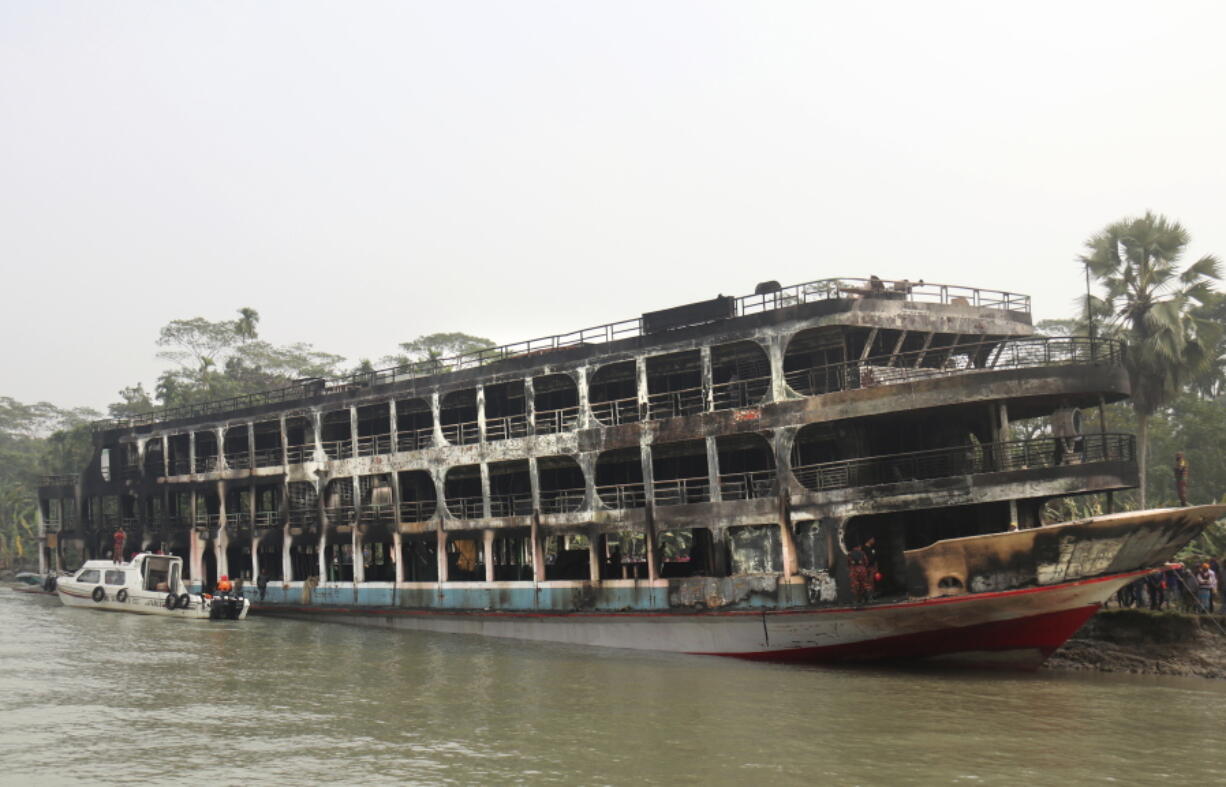 A burnt passenger ferry is seen anchored off the coast of Jhalokati district on the Sugandha River in Bangladesh, Friday, Dec. 24, 2021. Bangladesh fire services say at least 37 passengers have been killed and many others injured in a massive fire that swept through a ferry on the southern Sugandha River. The blaze broke out around 3 a.m. Friday on the ferry packed with 800 passengers.