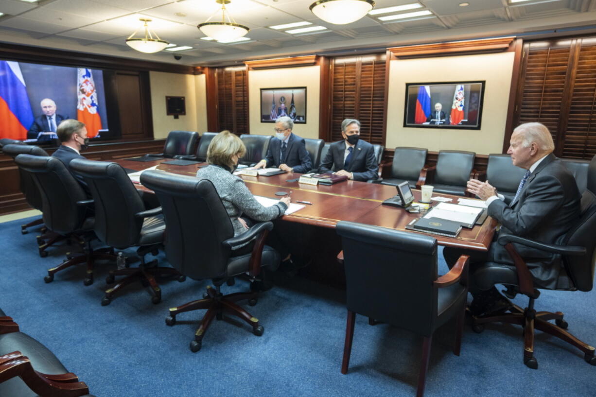 In this image provided by The White House, President Joe Biden speaks as he meets virtually via a secure video conference with Russian President Vladimir Putin from the Situation Room at the White House in Washington, Tuesday, Dec. 7, 2021. At far left is White House national security adviser Jake Sullivan along with Secretary of State Antony Blinken, right, national security council senior director for Russian and Central Asia, Eric Green.