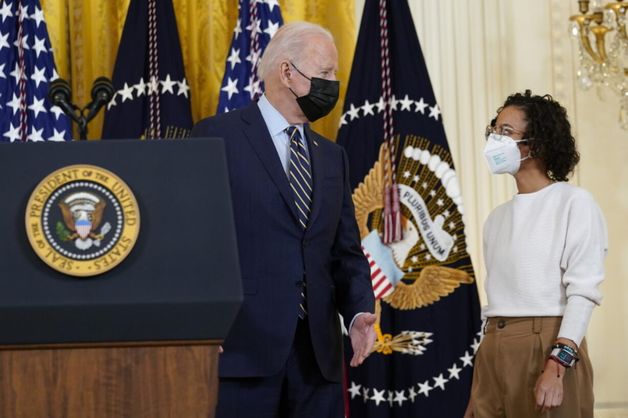 President Joe Biden talks with Iesha Meza, who introduced Biden to speak, in the East Room of the White House in Washington, Monday, Dec. 6, 2021. Biden talked about his administrations plans to lower the costs of prescription drugs, letting Medicare negotiate drug prices, capping how much seniors and people with disabilities have to pay for drugs.