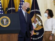 President Joe Biden talks with Iesha Meza, who introduced Biden to speak, in the East Room of the White House in Washington, Monday, Dec. 6, 2021. Biden talked about his administrations plans to lower the costs of prescription drugs, letting Medicare negotiate drug prices, capping how much seniors and people with disabilities have to pay for drugs.