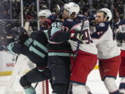 Seattle Kraken center Alexander True (11) and defenseman Jeremy Lauzon (55) scuffle with Columbus Blue Jackets defenseman Vladislav Gavrikov, second from left, right wing Jakub Voracek (93) and defenseman Andrew Peeke during the second period of an NHL hockey game Saturday, Dec. 11, 2021, in Seattle.