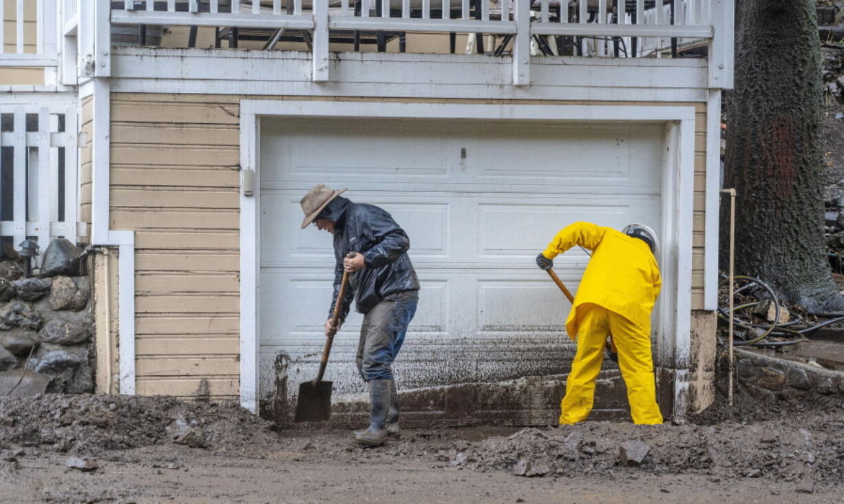 Residents dig out from a mudslide covering part of Silverado Canyon Road in Silverado, located in eastern Orange County, Calif., as a winter storm brought heavy rain and flash flooding to Orange County and Southern California on Tuesday, Dec. 14, 2021.