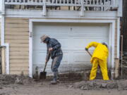 Residents dig out from a mudslide covering part of Silverado Canyon Road in Silverado, located in eastern Orange County, Calif., as a winter storm brought heavy rain and flash flooding to Orange County and Southern California on Tuesday, Dec. 14, 2021.