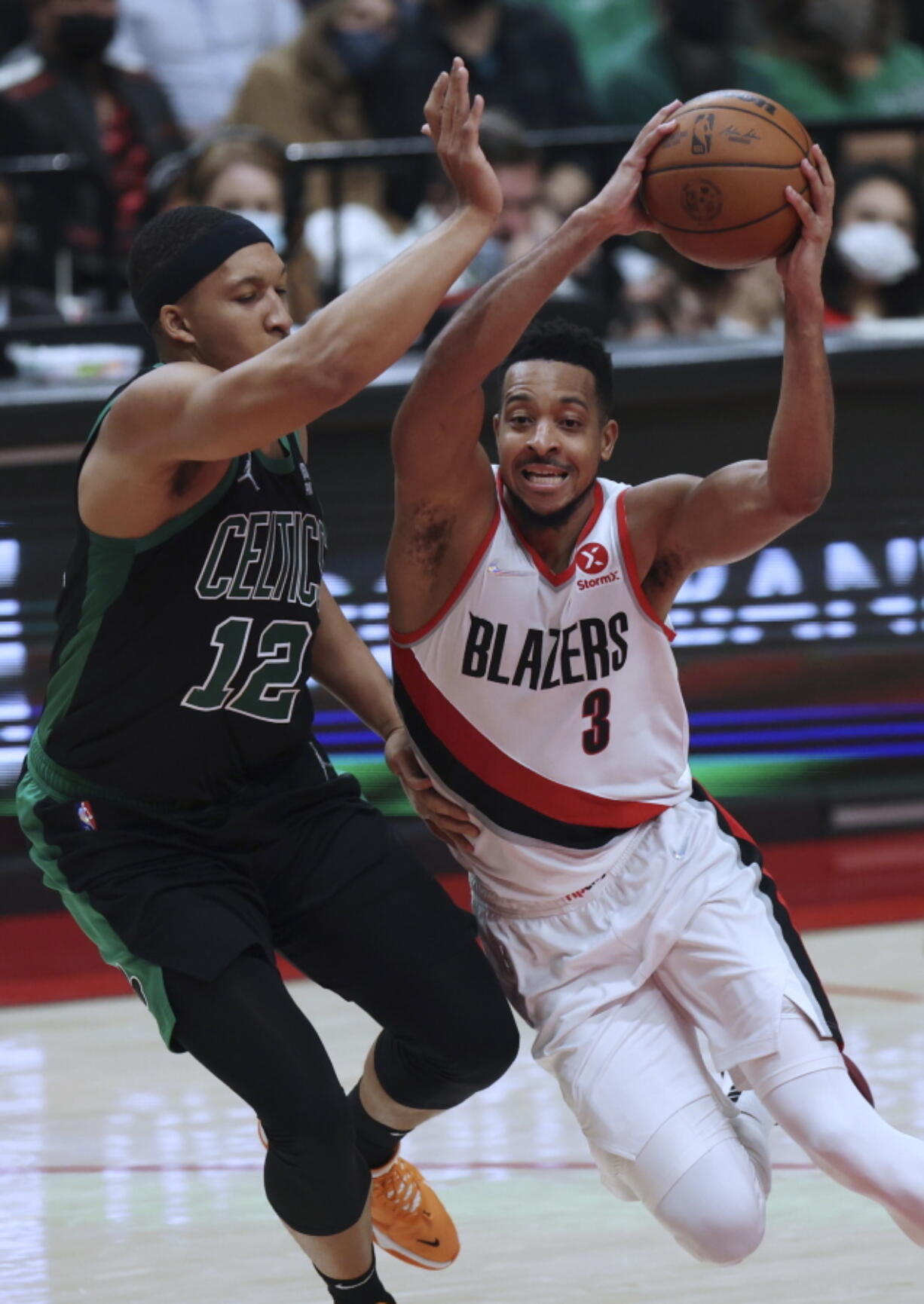 Portland Trail Blazers guard CJ McCollum, right, drives against Boston Celtics forward Grant Williams during the second half of an NBA basketball game in Portland, Ore., Saturday, Dec. 4, 2021. The Celtics won 145-117.