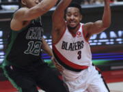 Portland Trail Blazers guard CJ McCollum, right, drives against Boston Celtics forward Grant Williams during the second half of an NBA basketball game in Portland, Ore., Saturday, Dec. 4, 2021. The Celtics won 145-117.