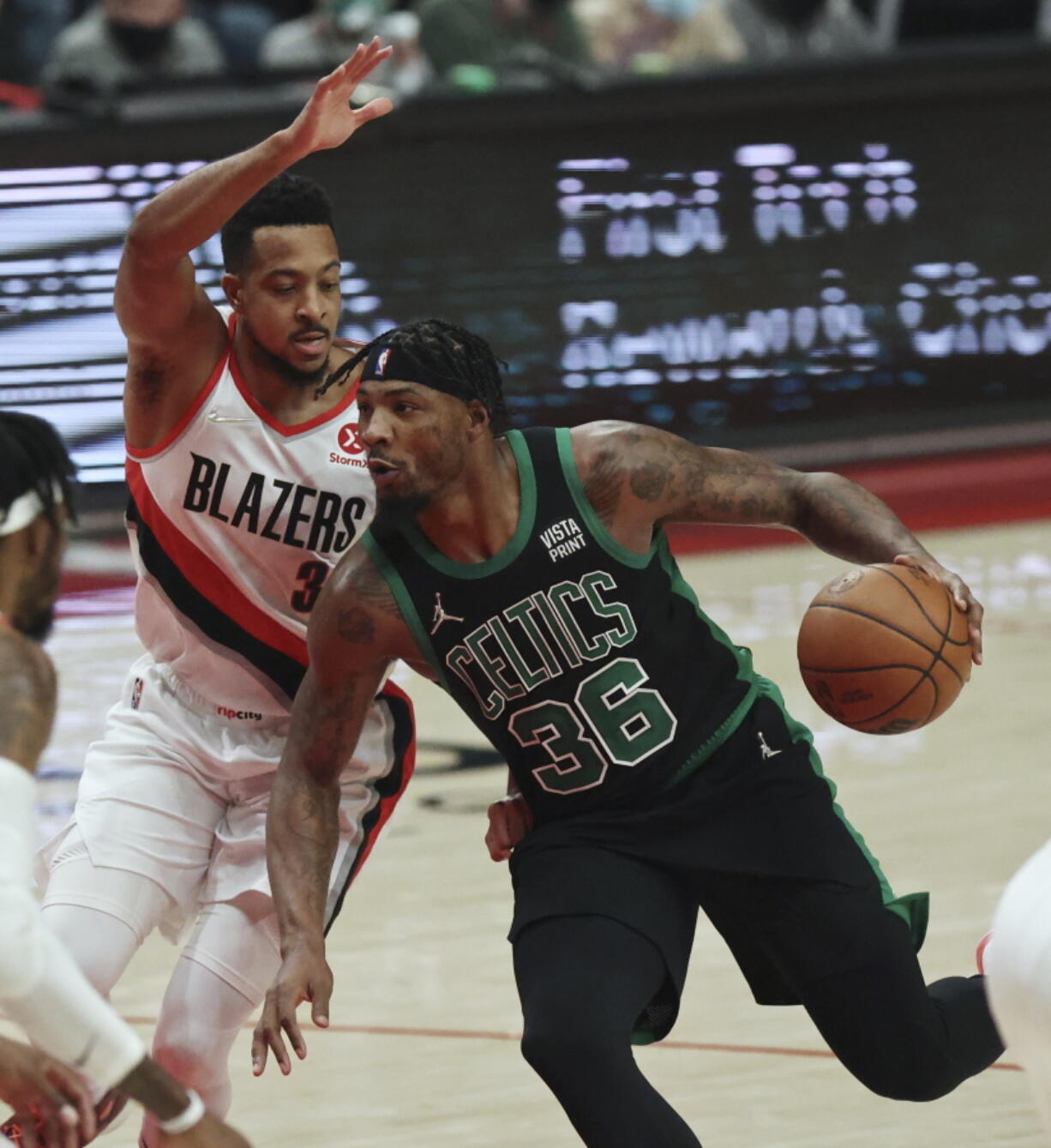 Boston Celtics guard Marcus Smart, right, drives against Portland Trail Blazers guard CJ McCollum, left, during the first half of an NBA basketball game in Portland, Ore., Saturday, Dec. 4, 2021.