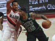 Boston Celtics guard Marcus Smart, right, drives against Portland Trail Blazers guard CJ McCollum, left, during the first half of an NBA basketball game in Portland, Ore., Saturday, Dec. 4, 2021.