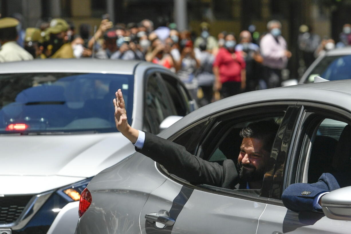 Chilean President-elect Gabriel Boric waves to supporters as he arrives to La Moneda presidential palace for a meeting with current President Sebastian Pinera in Santiago, Chile, on Monday.