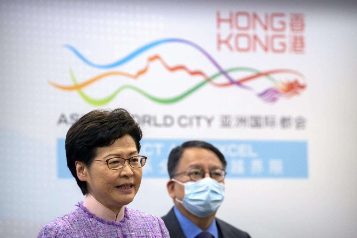 Hong Kong Chief Executive Carrie Lam, left, speaks as Eric Chan, director of the Chief Executive's Office, listens during a press conference in Beijing, Wednesday, Dec. 22, 2021. Hong Kong's leader Carrie Lam met with top leaders in Beijing on Wednesday to report to them on the territory's first legislative elections held under new laws ensuring that only "patriots" loyal to the ruling Chinese Communist Party could run as candidates.