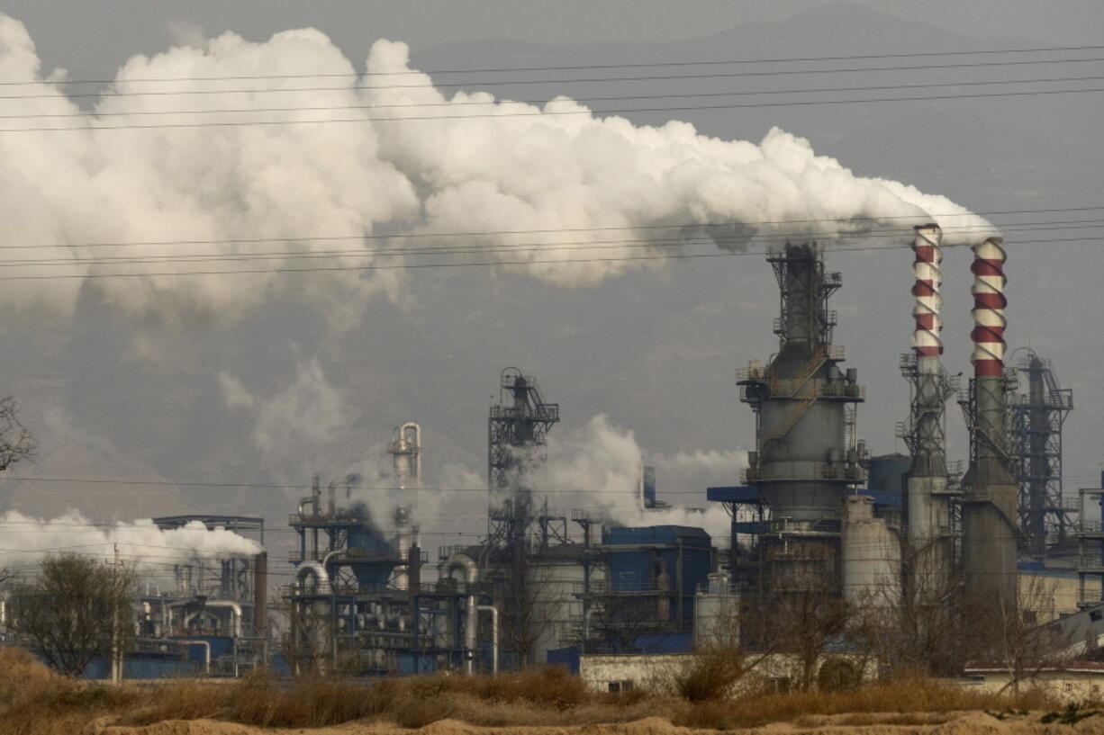 FILE - In this Nov. 28, 2019, file photo, smoke and steam rise from a coal processing plant in Hejin in central China's Shanxi Province. China and U.S. had a "very good year" for collaboration on dealing with climate change, but Washington is still pushing Beijing to adopt more ambitious carbon reduction goals, the top U.S. diplomat in China says.