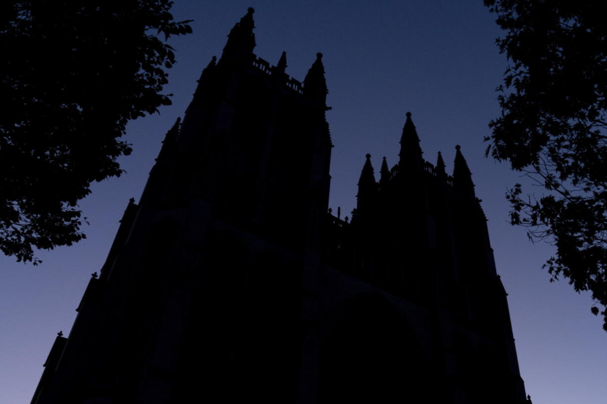 FILE - The Washington National Cathedral is seen at dawn in Washington on Friday, Nov. 5, 2021. Amid the surge of coronavirus cases across the U.S., this and many other churches have cancelled in-person Christmas services, disappointing pastors and churchgoers who consider them an annual highlight.