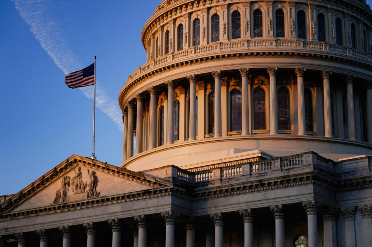 Light from the morning sun illuminates the Capitol in Washington, Friday, Dec. 3, 2021. With Democrats holding a thin majority in Congress, passage of President Joe Biden's sweeping legislative agenda will be a challenge as negotiations continue in the 50-50 Senate. (AP Photo/J.